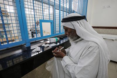 Palestinians wait to receive a medication ration at the UNRWA-run clinic at al-Shati refugee camp-stock-foto