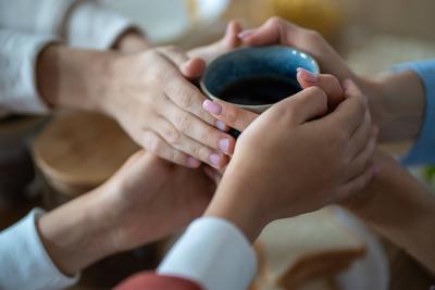 Familie h?lt Tasse Tee in den H?nden, w?rmend in kalter Wohnung-stock-foto