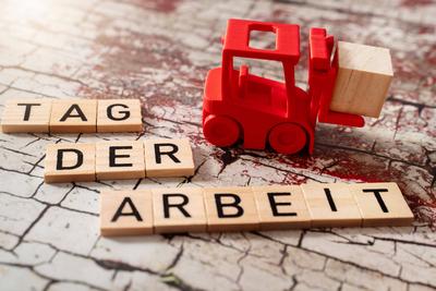 Bavaria, Germany - April 17, 2025: A red forklift lifts a block of wood, next to it the message Labor Day in letters - s-stock-foto