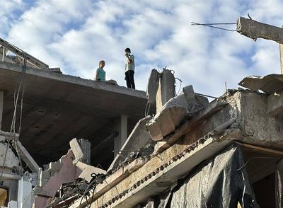 Palestinians inspect the damage, following overnight Israeli strikes on homes, in the after the Israeli army bombed Downtown Khan Yunis-stock-foto