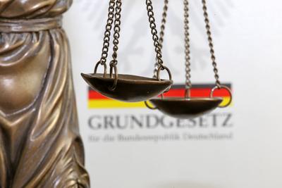 Close-up of a Justitia in front of a german basic law book *** Close up of a Justitia in front of a german basic law bo-stock-photo