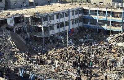 Palestinians inspect the damage caused by an Israeli airstrike targeting a school housing displaced people for the second time in Al-Bureij-stock-foto