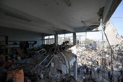 Palestinians inspect the damage caused by an Israeli airstrike targeting a school housing displaced people for the second time in Al-Bureij-stock-foto