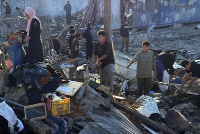 Palestinians inspect the damage caused by an Israeli airstrike targeting a school housing displaced people for the second time in Al-Bureij-stock-foto