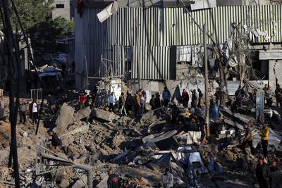 Palestinians inspect the damage caused by an Israeli airstrike targeting a school housing displaced people for the second time in Al-Bureij-stock-foto