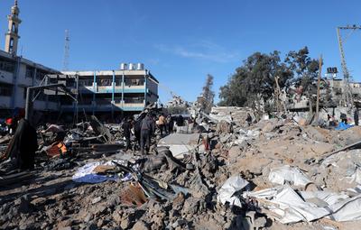 Palestinians inspect the damage caused by an Israeli airstrike targeting a school housing displaced people for the second time in Al-Bureij-stock-foto