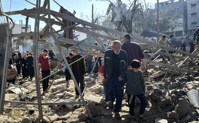 Palestinians inspect the damage caused by an Israeli airstrike targeting a school housing displaced people for the second time in Al-Bureij-stock-foto