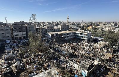 Palestinians inspect the damage caused by an Israeli airstrike targeting a school housing displaced people for the second time in Al-Bureij-stock-foto