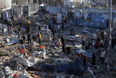 Palestinians inspect the damage caused by an Israeli airstrike targeting a school housing displaced people for the second time in Al-Bureij-stock-foto