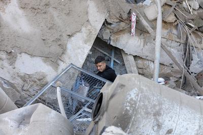Palestinians inspect the damage caused by an Israeli airstrike targeting a school housing displaced people for the second time in Al-Bureij-stock-foto