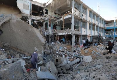 Palestinians inspect the damage caused by an Israeli airstrike targeting a school housing displaced people for the second time in Al-Bureij-stock-foto