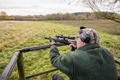 Ein Jaeger sitzt mit einem Gewehr auf einem Hochsitz Ein Jaeger bei der Jagd Themenbild Symbolbild-stock-foto