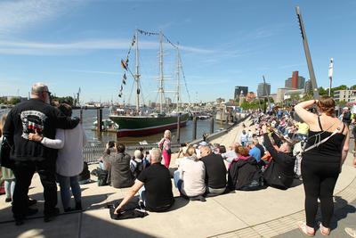 836. Hamburger Hafengeburtstag. Besucher sitzen auf den Treppen an er Jan-Fedder-Promenade und schauen auf die Elbe. Im-stock-foto