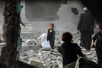Palestinians inspect the rubble of A school Fatima, Asad's daughter, After the Israeli bombing last night at Jabalia-stock-foto
