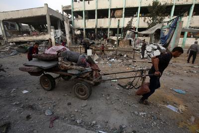 Palestinians inspect the rubble of A school Fatima, Asad's daughter, After the Israeli bombing last night at Jabalia-stock-foto