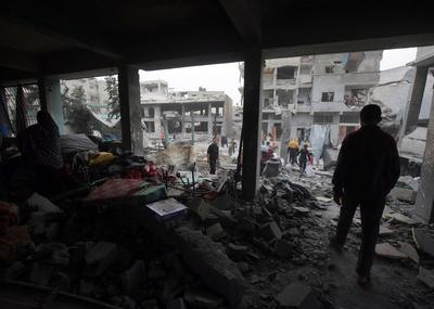 Palestinians inspect the rubble of A school Fatima, Asad's daughter, After the Israeli bombing last night at Jabalia-stock-foto