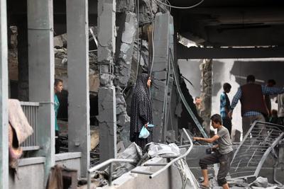 Palestinians inspect the rubble of A school Fatima, Asad's daughter, After the Israeli bombing last night at Jabalia-stock-foto