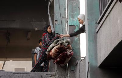 Palestinians inspect the rubble of A school Fatima, Asad's daughter, After the Israeli bombing last night at Jabalia-stock-foto