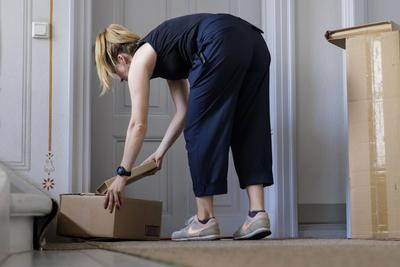 Eine Frau stellt ihrem Nachbarn ein Paket vor die Haustuer in Berlin, 08.08.2024. Berlin Deutschland *** A woman puts a-stock-foto