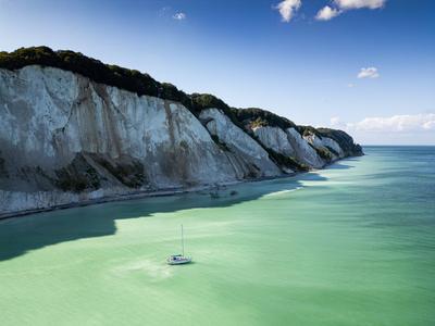 Segelboot vor Steilk?ste Ein Segelboot liegt bei sonnigem Wetter vor den M?ns Klint, der h?chsten Steilk?ste D?nemarks v-stock-photo