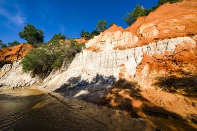 Orange and white coloured cliffs with small trees in the little canyon Fairy Stream, Suoi Tien, Suối Tiên near Mui Ne-stock-photo