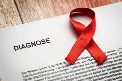 25 February 2023: Diagnosis from the doctor - cancer. Document with the inscription diagnosis and a red ribbon. Symbol i-stock-foto