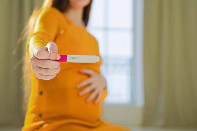 Frau Hand h?lt positiven Schwangerschaftstest. Schwangere Frau mit gro?en Bauch erwartet Baby unterziehen Fruchtbarkeit Unfruchtbarkeit Behandlung IVF. Schwangerschaft Mutterschaft Zukunft Mutterschaft Elternschaft neues Leben-stock-photo