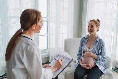 Weiblicher Arzt untersucht schwangere Frau in Arztpraxis. Schwangere M?dchen Patienten haben Beratung im Krankenhaus. Gyn?kologe Arzt ber?t Patientin ?ber Schwangerschaft. Besuch beim Arzt medizinische Untersuchung.-stock-photo