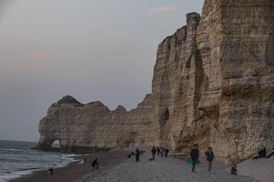 Climate change and overtourism threaten France s coastlines Tourists walk next to an arch cliff, carved by waves, on the-stock-foto