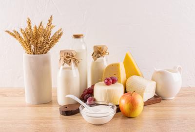 Ein wundersch?nes Stillleben in Wei?t?nen mit traditionellen Milchprodukten f?r den Feiertag Schawuot und einem Symbol f?r den Feiertag, den Weizen?hren in einer Vase.-stock-foto