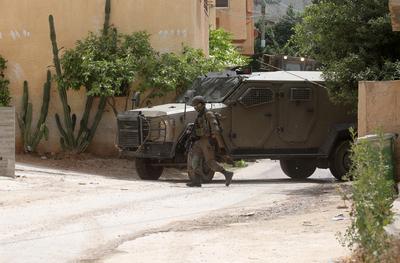Israeli military vehicles and bulldozers surround a Palestinian house in the town of Tammun during an Israeli army raid in Tubas-stock-foto