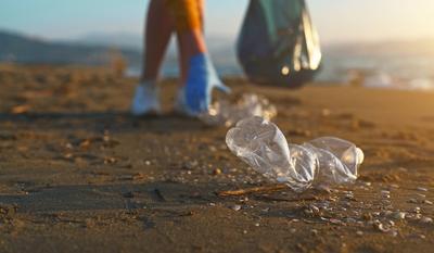 Freiwillige Frau sammelt am Strand M?ll ein. Umweltverschmutzung.-stock-foto