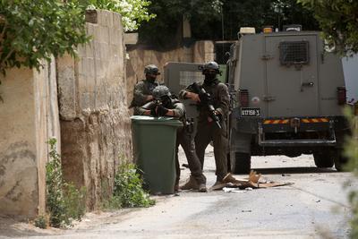 Israeli military vehicles and bulldozers surround a Palestinian house in the town of Tammun during an Israeli army raid in Tubas-stock-foto