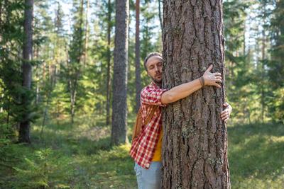 Entspannt Mann mit geschlossenen Augen genie?en Wandern im Wald umarmt Baum f?hlt sich Freiheit Atem der Natur.-stock-photo