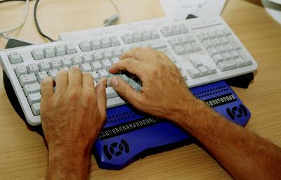 Rehabilitation of the blind Refreshable braille display linked to the computer of blind persons. model release Copyright-stock-foto