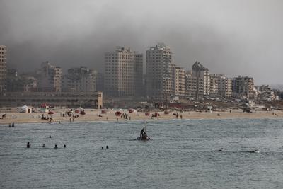 Palestinians, struggling with harsh living conditions due to ongoing Israeli attacks on the Gaza Strip and an intensifying heatwave, gather on the coast to cool off, spending the evening hours by the seaside to escape the stifling heat inside their tents-stock-foto