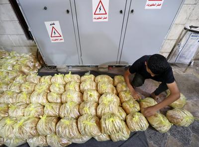 Workers package bread for distribution at the World Food Programme (WFP) bakery after a limited amount of flour entered the Gaza Strip-stock-foto