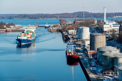 Ein aus der Ostsee kommender Containerfrachter verl??t die Schleuse in Holtenau in den Kanal auf dem Weg nach Brunsb?tte-stock-foto