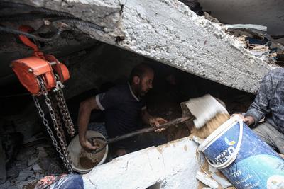 Rescuers remove the bodys from under the rubble, following an Israeli strike that hit the home of a Palestinian family in Jabalia in the northern Gaza Strip-stock-foto