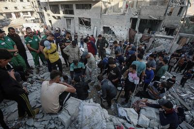 Rescuers remove the bodys from under the rubble, following an Israeli strike that hit the home of a Palestinian family in Jabalia in the northern Gaza Strip-stock-foto