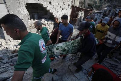Rescuers remove the bodys from under the rubble, following an Israeli strike that hit the home of a Palestinian family in Jabalia in the northern Gaza Strip-stock-foto