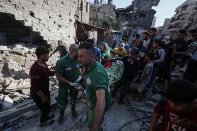 Rescuers remove the bodys from under the rubble, following an Israeli strike that hit the home of a Palestinian family in Jabalia in the northern Gaza Strip-stock-foto