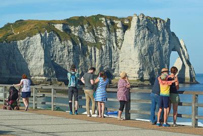 Etretat, Normandie , France Tourists on the promenade, morning , sunny day Menschn am Strand am fruehen Morgen Copyright-stock-foto