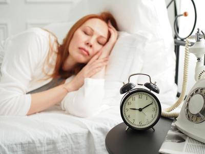 Wecker vor dem Hintergrund eines wachen M?dchens. Wecker Fokus-stock-photo