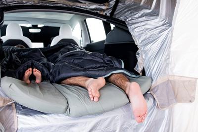 Gem?tliches Autocamping mit der Familie. Erwachsene und Kind schlafen im Auto mit Schlafs?cken-stock-foto
