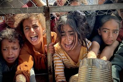 Palestinians wait in long queues to receive pots of food distributed by charitable organizations, as they face food crisis-stock-photo