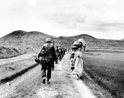 RECORD DATE NOT STATED Korea: During the Korean War (1950-1953), a line of US Army soldiers file past a group of Korean-stock-photo
