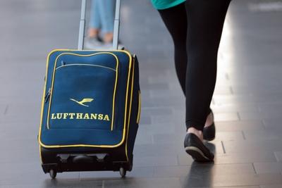 Frau und Rollkoffer mit Lufthansa Logo unterwegs im Hauptbahnhof Frankfurt, Hessen, Deutschland-stock-foto