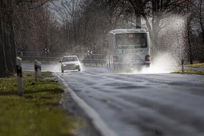 Ein Bus faehrt nach einem Regenschauer durch eine grosse Pfuetze, aufgenommen in Wustermark, 18.02.2020. Wustermark Deut-stock-foto