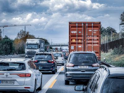 Stau auf Autobahn, Lkw, Autos, Br?cke, Baukran, bew?lkter Himmel, Herbst, Verkehrsstau, Lieferkettenprobleme, Infrastruk-stock-foto
